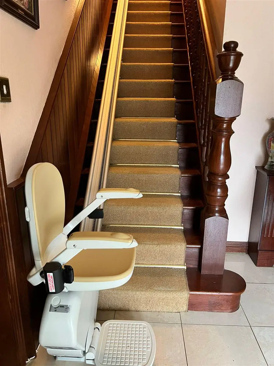 Reconditioned straight stairlift installed alongside a narrow staircase