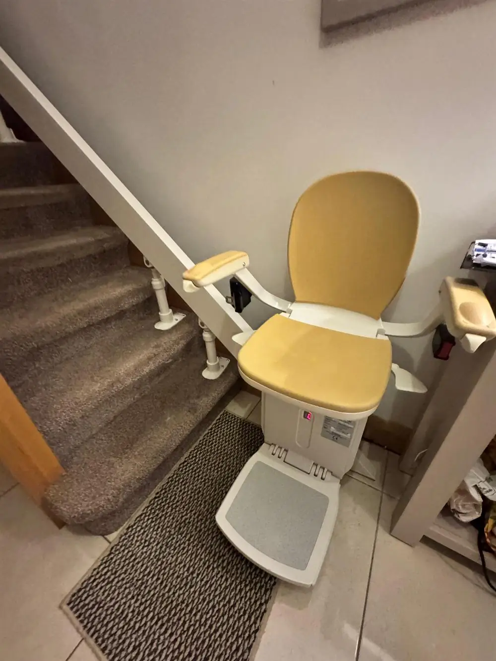 Beige curved stairlift installed beside a compact staircase in Sligo