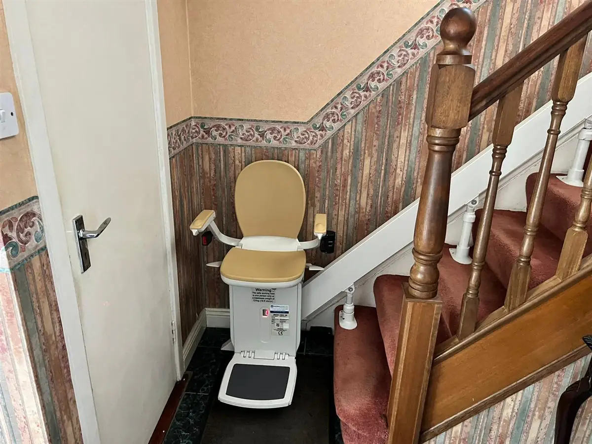 Stairlift rail fitted around the lower turn of a home staircase