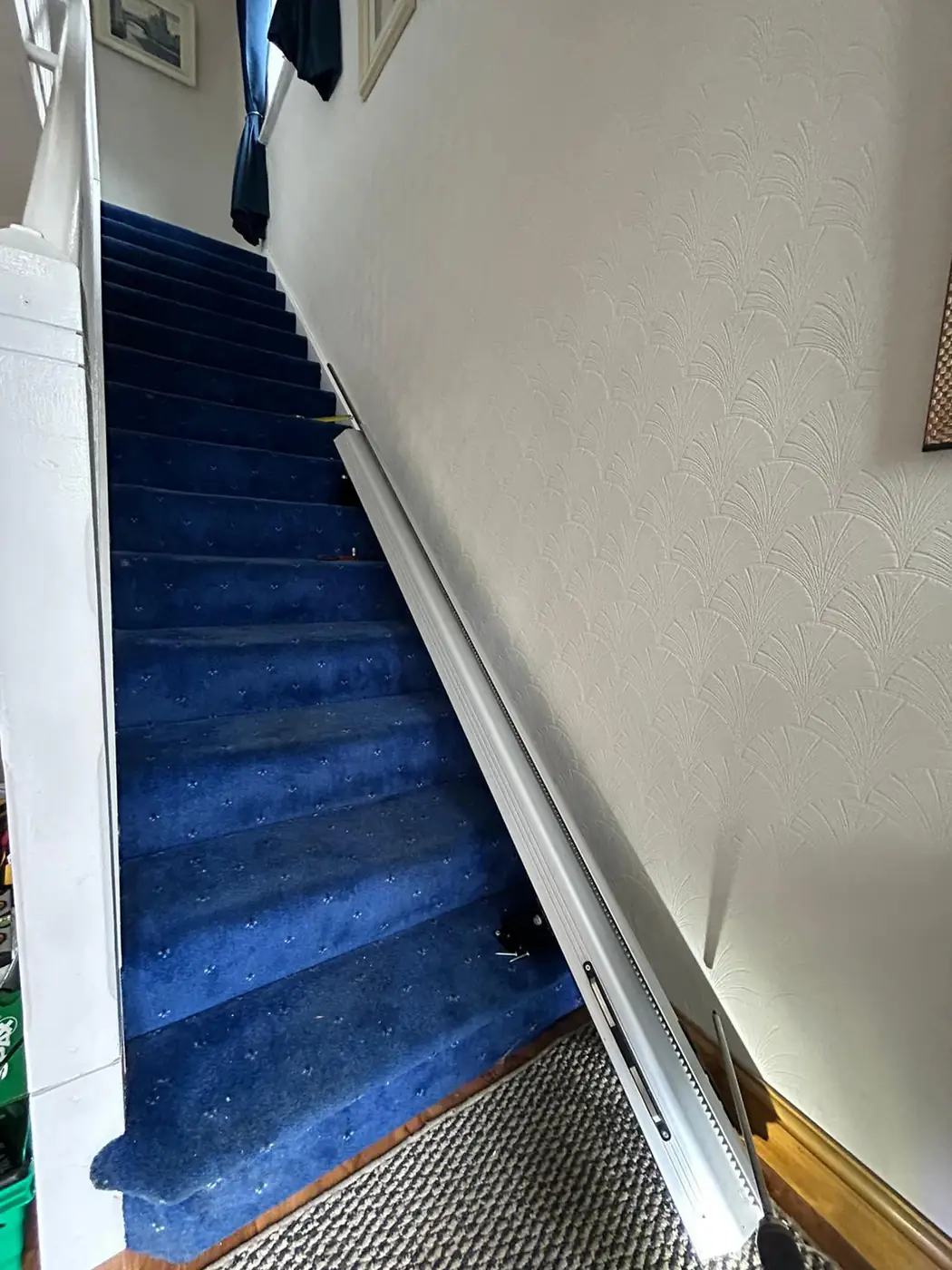 Rental stairlift installed at the foot of a home staircase