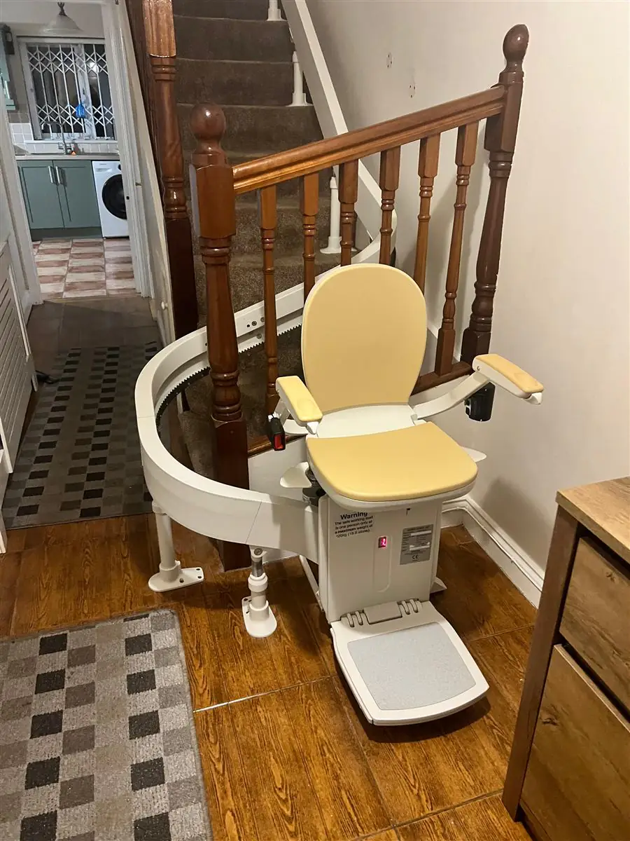 Curved stairlift wrapped neatly around the base of a timber staircase