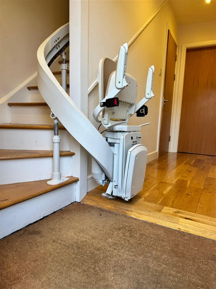 Curved stairlift rail following the inside edge of a turning staircase