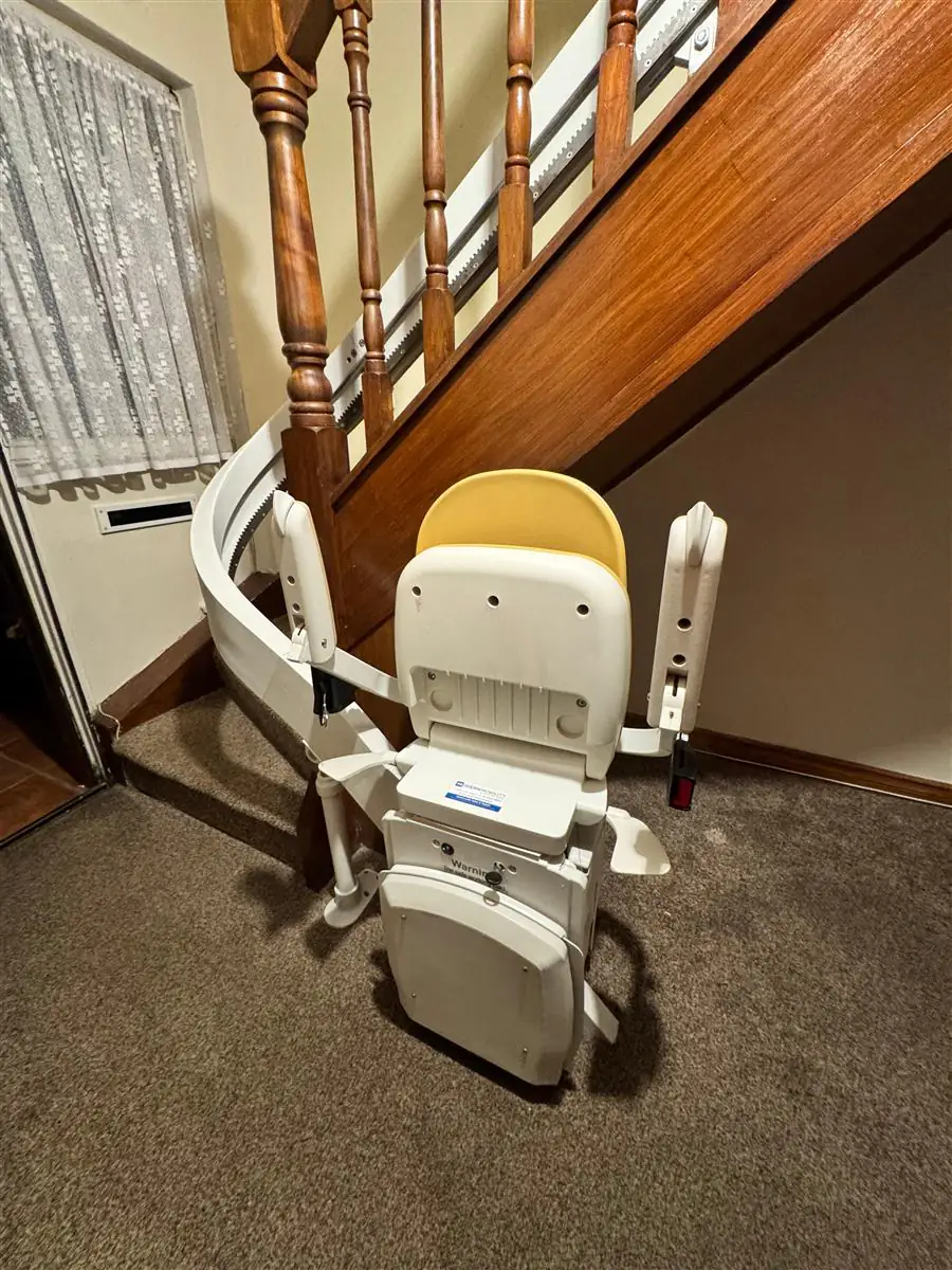 Curved stairlift parked neatly around the bottom newel post