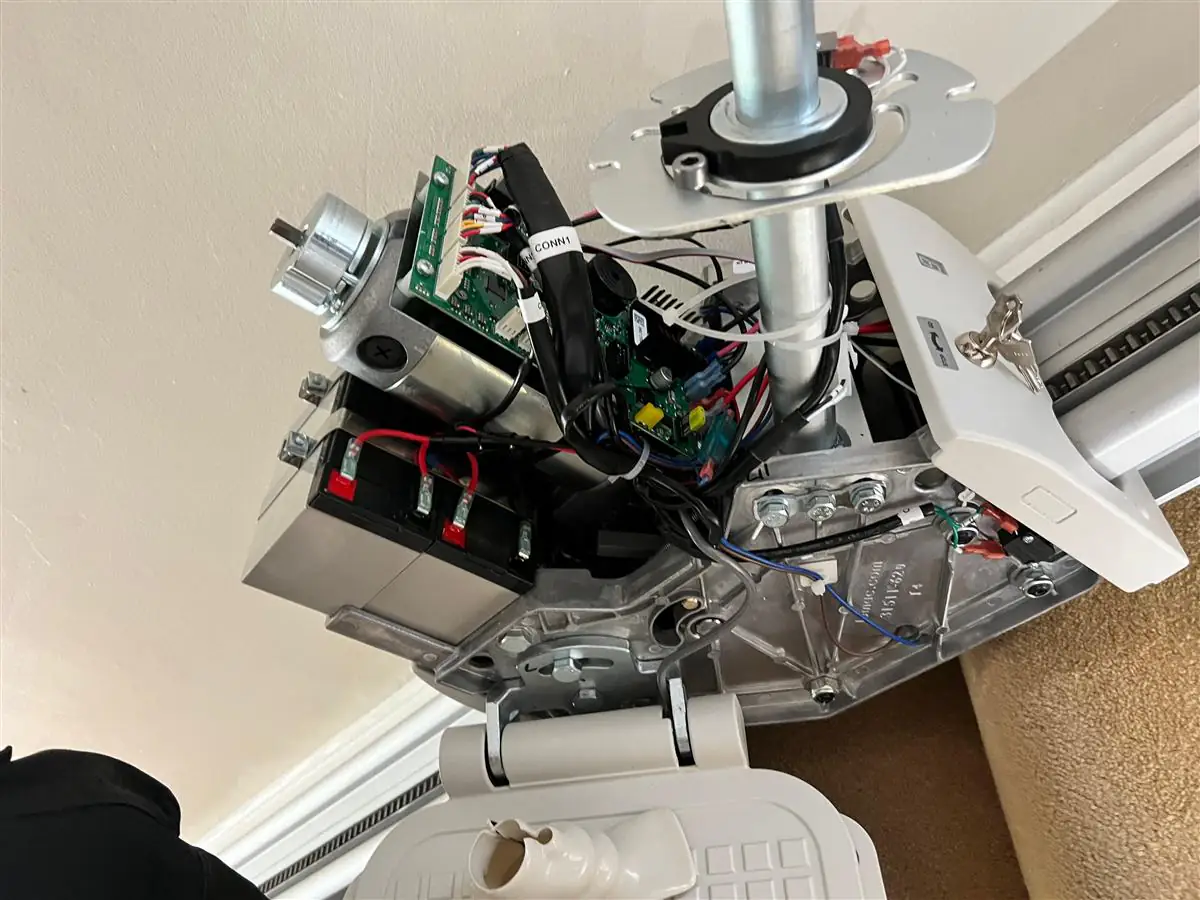 Open stairlift carriage showing the motor, control boards and internal wiring during repair